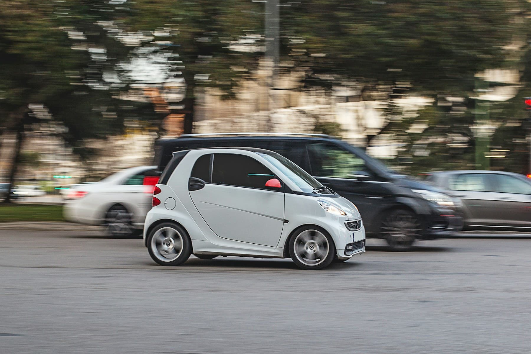 Carro compacto em movimento em uma avenida urbana. Imagem ilustrativa, sem vínculo com a frota.